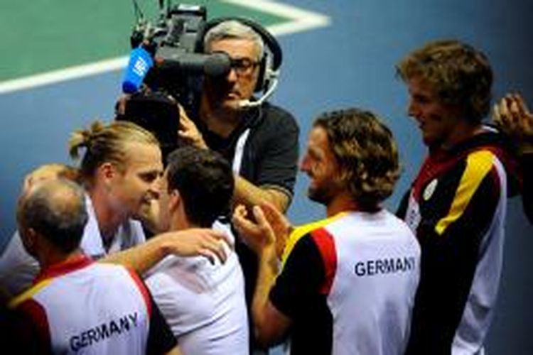 Petenis Jerman Peter Gojowczyk (dua dari kiri) mendapat ucapan selamat dari rekan-rekan satu timnya setelah mengalahkan Jo-Wilfried Tsonga dari Perancis pada laga kedua perempat final Davis Cup di Nancy, Jumat (4/4/2014).