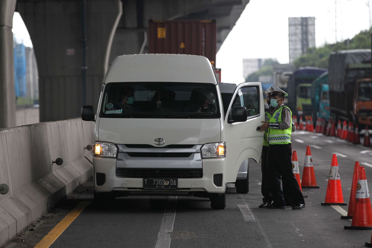 Petugas melakukan pemeriksaan di check point penyekatan pertama di ruas tol Jakarta - Cikampek Km 31, Kabupaten Bekasi, Jawa Barat, Jumat (24/4/2020). Larangan mudik mulai diberlakukan pemerintah mulai 24 April 2020 pukul 00.00 WIB untuk mencegah penyebaran Covid-19 melalui Operasi Ketupat 2020. Kendaraan pribadi baik motor atau mobil dan kendaraan umum berpenumpang dilarang keluar dari wilayah Jabodetabek.