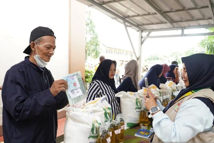 Sejumlah warga mengantre untuk mendapatkan bantuan pangan beras dan minyak goreng dari pemerintah sebagai stimulus ekonomi. 