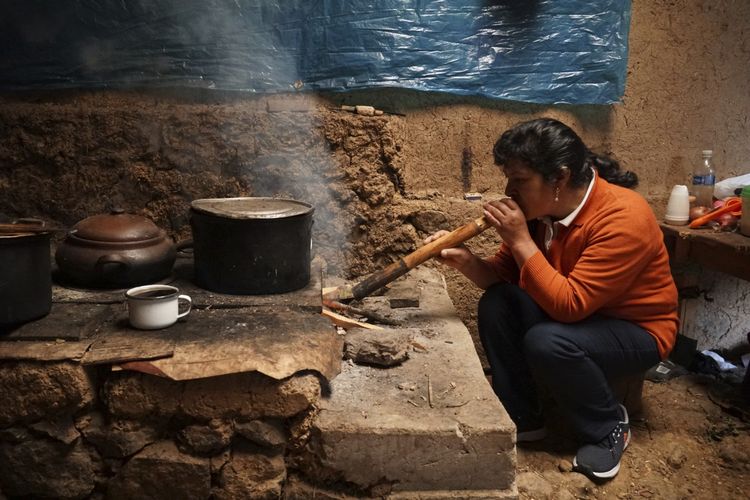 Ibu negara Peru, Lilia Paredes (48), sedang meniup tungku untuk membakar kayu di rumah gubuknya di Chugur, Peru, Kamis (22/7/2021). Suaminya, Pedro Castillo, terpilih sebagai presiden baru Peru berkat dukungan warga miskin dan pinggiran, yang merasa senasib dengan pria berprofesi guru tersebut.