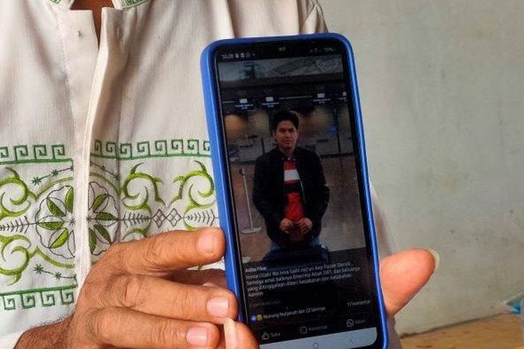 Dasuki (61) menunjukkan foto anaknya, Aep Priyano (35). Aep menjadi salah satu korban tewas dalam kecelakaan bus di Tol Jakarta-Cikampek, Minggu (31/12/2023).