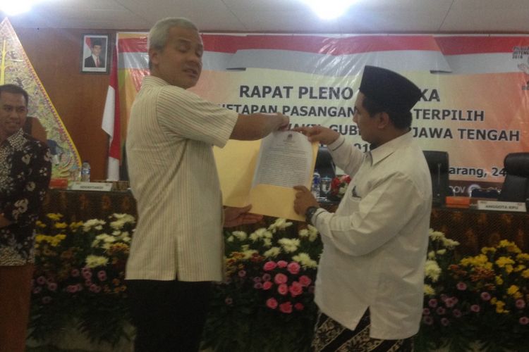 Ganjar Pranowo dan Taj Yasin memegang surat keputusan dari KPU Jawa Tengah seusai sidang pleno penetapan pasangan calon terpilih, Selasa (24/7/2018).