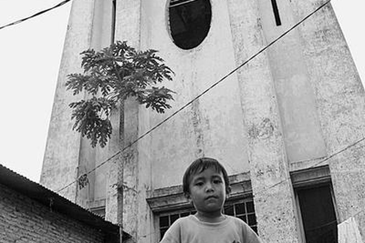 Kiki (3) berdiri di depan tempat penyimpanan air yang dibangun awal abad ke-20 di Kelurahan Pulo Brayan Bengkel Baru, Kecamatan Medan Timur, Medan, Minggu (18/1). Tandon air ini pada saat itu berfungsi sebagai tempat penyimpanan air untuk memenuhi kebutuhan masyarakat di kawasan tersebut.  