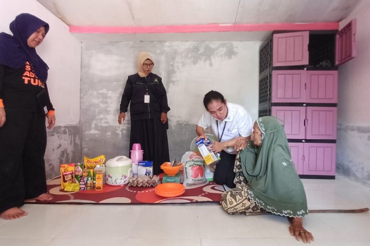Aisyah (80) warga Desa Pulo Rungkom, Aceh Utara saat menerima bantuan makanan dan bahan pokok dari Kementerian Sosial RI, Senin (27/5/2024).