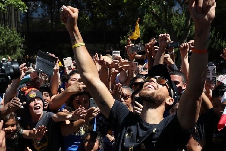 Pebasket Golden State Warriors, Stephen Curry, melakukan selebrasi bersama para fans pada parade kemenangan yang berlangsung di kota Oakland California, Amerika Serikat, 15 Juni 2017.