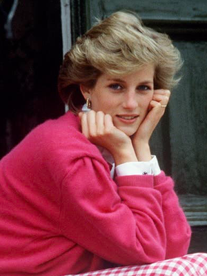 Putri Diana diabadikan saat mengenakan celana panjang motif kotak-kotak berwarna merah muda yang serasi dengan jumper merah muda dan kemeja putih. 