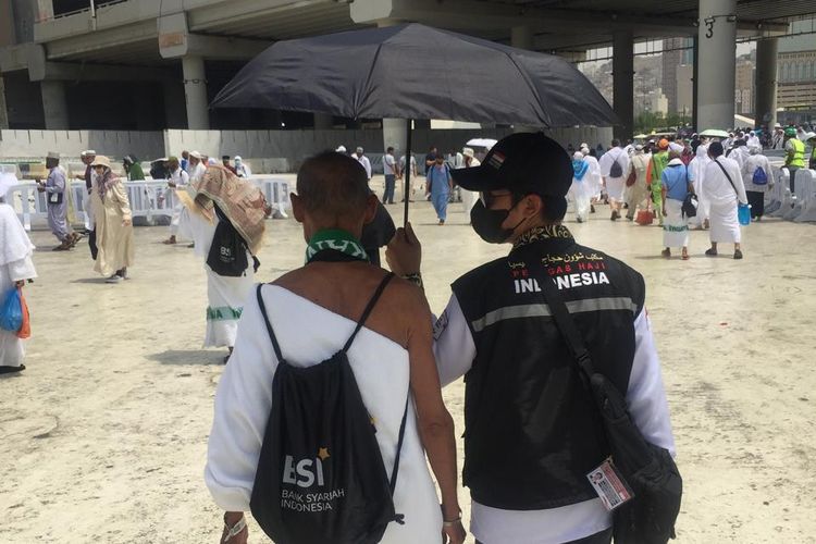 Petugas Haji tengah membantu jamaah.