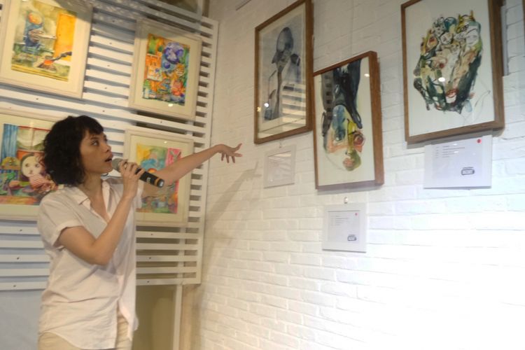 Seniman Ruth Marbun saat menjelaskan karya lukisnya pada acara pembukaan Buzzing Art di 2madison gallery, Kemang, Jakarta Selatan, Sabtu (27/1/2018).