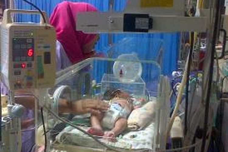Untuk pertama kalinya Yani Mulyani (33) melihat putra ketiganya, Ginan Septian Nugraha pasca operasi pemisahan antara tubuh sehat dengan bayi parasit (tumor teratoma epignathus), Kamis (26/9/2013)