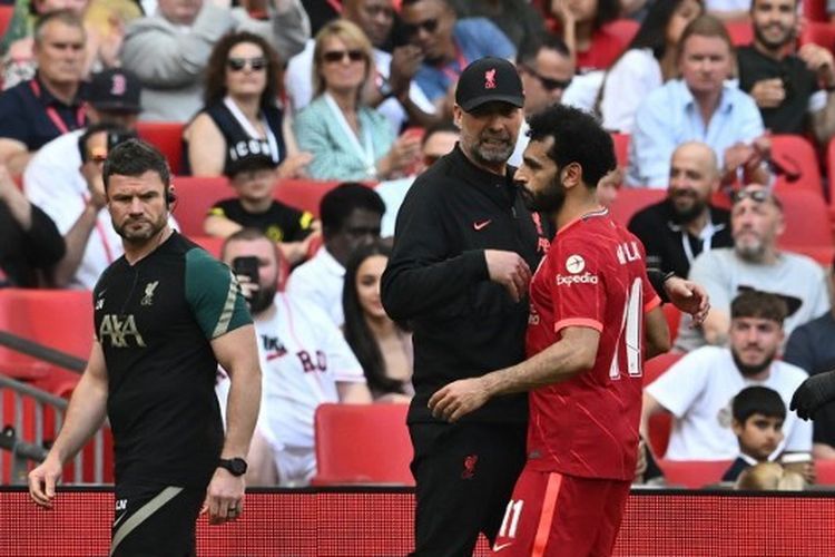 Pelatih Liverpool, Juergen Klopp, berbicara kepada Mohamed Salah setelah sang penyerang menderita cedera pada final Piala FA kontra Chelsea, Sabtu (14/5/2022). Terkini, Klopp buka suara soal reaksi Mo Salah setelah kegagalan Liverpool lolos ke Liga Champions. 