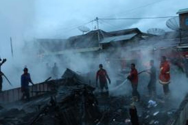 Sejumlah petugas pemadam kebakaran sedang berupaya memadamkan api dalam sebuah peristiwa kebakaran di Takengon, Aceh Tengah, Aceh.