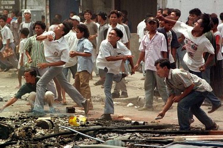 Aksi para perusuh yang melemparkan batu ke sebuah toko milik etnis Tionghoa di Medan, Sumatera Utara, pada 6 Mei 1998.
