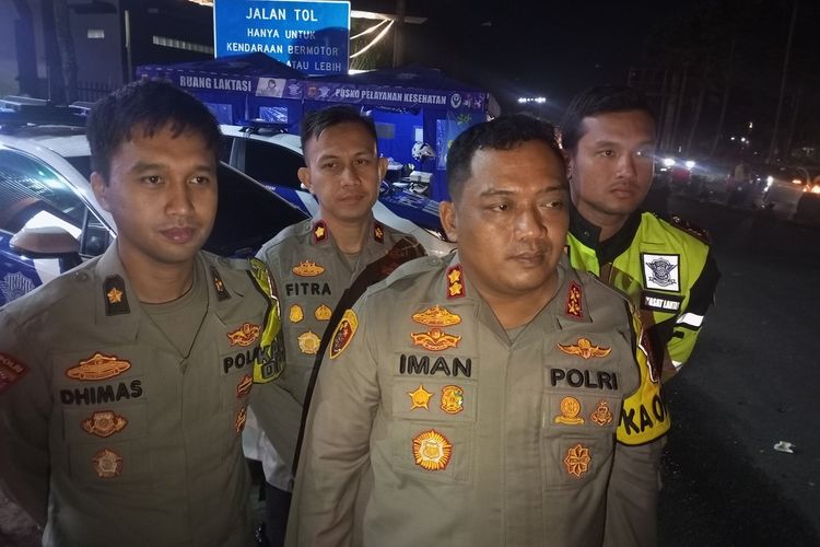 Kapolres Bogor AKBP Iman Imanuddin didampingi anggota kepolisian usai memantau arus lalu lintas di Puncak Bogor, Jawa Barat, Minggu (23/4/2023) pukul 23.40 WIB. Polisi akan memberlakukan ganjil genap lebih awal untuk menghindari penumpukan kendaraan.