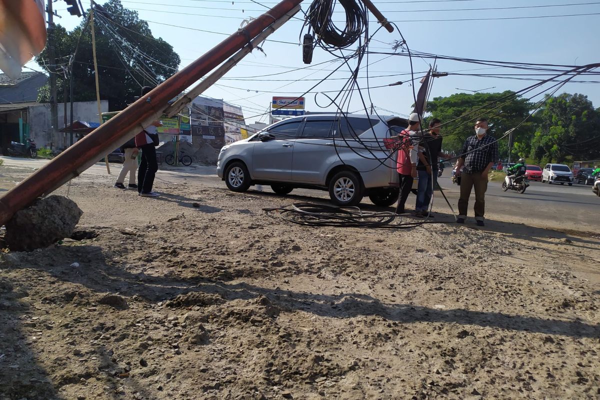 Tiang kabel telepon jatuh menimpa gerobak es buah di Ciater, Tangerang Selatan, Kamis (16/9/2021). 