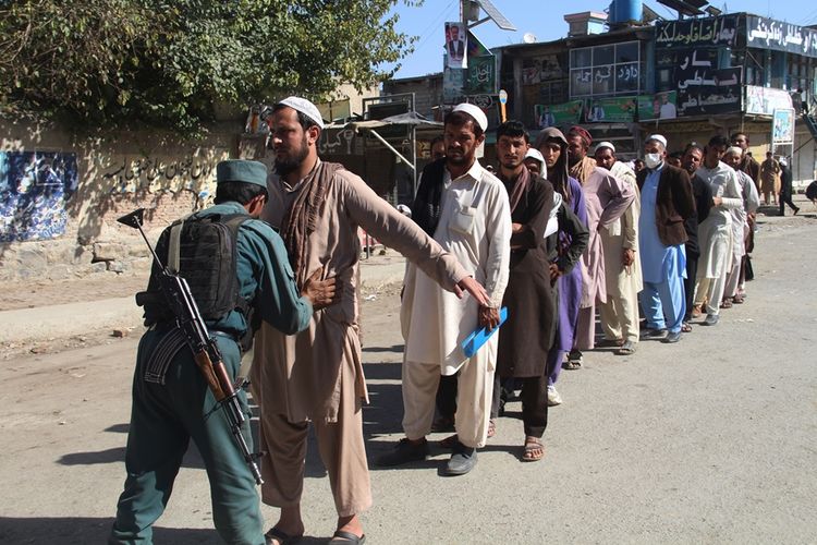 Petugas keamanan memeriksa warga yang hendak memasuki tempat pemungutan suara untuk memberikan suaranya dalam pemilihan legislatif di Provinsi Khost, Afghanistan, Sabtu (20/10/2018).