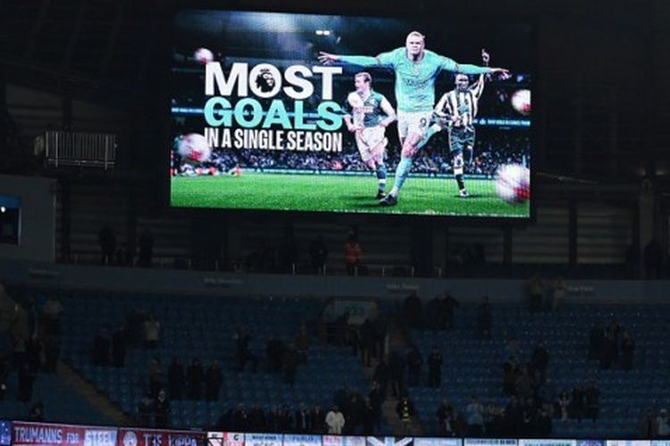 Layar besar menunjukkan bahwa Erling Haaland merupakan pencetak gol terbanyak dalam semusim Premier League seusai laga Man City vs West Ham di Stadion Etihad, Kamis (4/5/2023) dini hari WIB. (Foto oleh AFP/OLI SCARF)