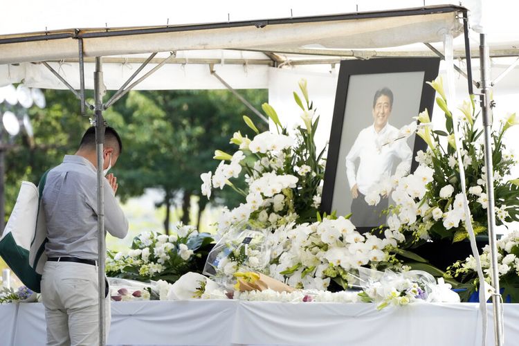 Seseorang mempersembahkan bunga dan doa untuk mantan Perdana Menteri Shinzo Abe, di kuil Zojoji sebelum pemakamannya Senin, 11 Juli 2022, di Tokyo. Abe dibunuh pada hari Jumat saat berkampanye di Nara, Jepang barat. 