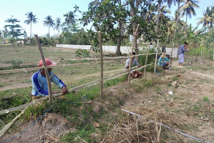 Warga memagar lahan di areal MotoGP di Lombok Tengah yang belum dibebaskan, Senin (30/9/2019).