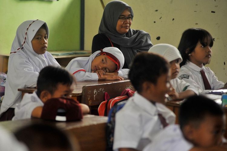 Seorang ibu duduk mendampingi anaknya saat hari pertama masuk sekolah di SD Negeri Sumber Agung, di Jalan Bayangkara, Serang, Banten, Senin (16/7). Pemerintah melalui Menteri Pendidikan mengingatkan pentingnya tanggung jawab orang tua membantu menyiapkan mental anak saat hari pertama masuk sekolah agar anak lebih percaya diri dan siap menyerap pelajaran di sekolah. 