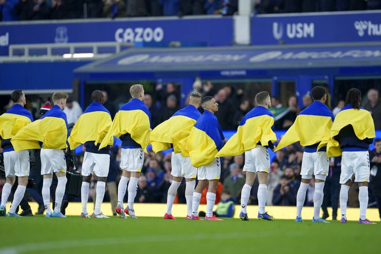 Pemain Everton memegang bendera Ukraina sebelum pertandingan sepak bola Liga Inggris antara Everton dan Manchester City di Goodison Park di Liverpool, Inggris, Sabtu, 26 Februari 2022.