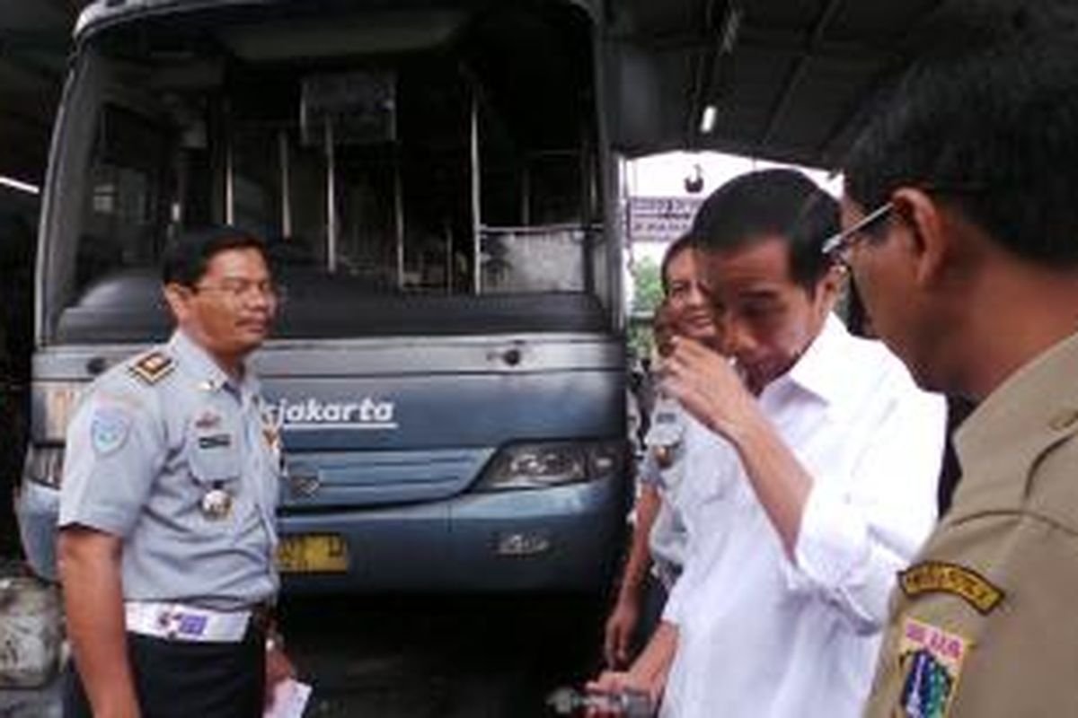 Gubernur DKI Jakarta Joko Widodo saat mengunjungi pool Transjakarta, Selasa (31/12/2013). Ia tampak terkejut mengetahui usia bus Teansjakarta yang mencapai 7-8 tahun.