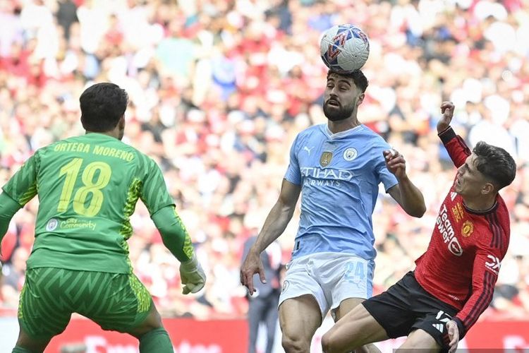Manchester City's Croatian defender #24 Josko Gvardiol (C) heads the ball past his team goalkeeper Manchester City's German goalkeeper #18 Stefan Ortega next to Manchester United's Argentinian midfielder #17 Alejandro Garnacho (R) during the English FA Cup final football match between Manchester City and Manchester United at Wembley stadium, in London, on May 25, 2024. (Photo by JUSTIN TALLIS / AFP) / NOT FOR MARKETING OR ADVERTISING USE / RESTRICTED TO EDITORIAL USE