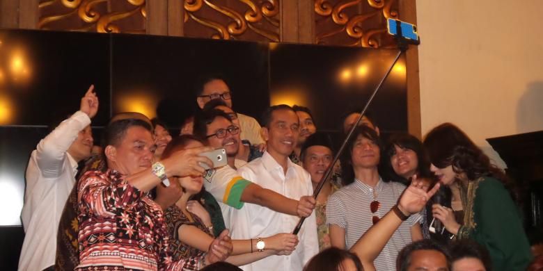 Presiden terpilih Joko Widodo saat melakukan selfie dengan para relawan dalam acara Halal Bihalal, di Kembang Goela Resto, Jakarta, Minggu (3/8/2014)