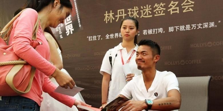 Pebulu tangkis China, Lin Dan (kanan) memberikan tanda tangan pada salah satu penggemarnya, di Shenzen, China, Selasa (26/11/2013).