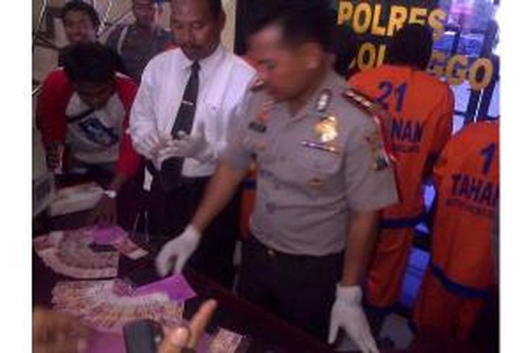 Kapolres Probolinggo AKBP Endar Priantoro menunjukkan uang palsu yang berhasil diamankan menjelang Pemilu 2014.