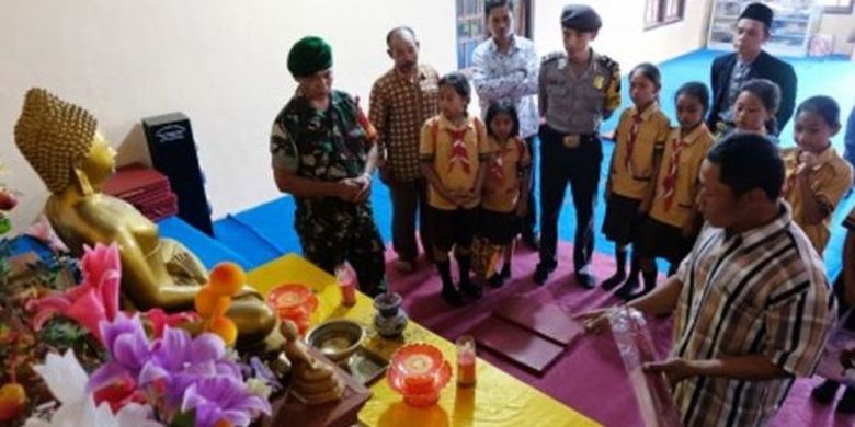 Anggota Bhabinkamtibmas dan Babinsa bersama rombongan mendengarkan penjelasan tokoh agama Buddha di vihara saat berkeliling mengunjungi tempat ibadah di kampung toleransi di Temanggung. 