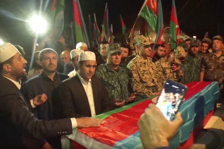 Dalam gambar yang diambil dari video ini, orang-orang berdiri di sekitar peti mati prajurit Azeri Elshan Babazade yang terbunuh di perbatasan Azerbaijan-Armenia, selama pemakamannya di Mykhlygovag, Azerbaijan, Selasa, 13 September 2022.