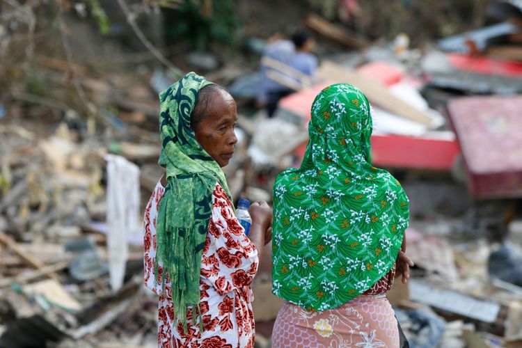 Moda (kiri) bersama saudaranya mencoba mencari barang berharga di bekas puing rumahnya di Desa Loli Saluran, Kecamatan Banawa, Kabupaten Donggala, Sulawesi Tengah, pasca gempa dan Tsunami, Rabu (3/10/2018). Gempa yang terjadi di Palu dan Donggala mengakibatkan 925 orang meninggal dunia dan 65.733 bangunan rusak.