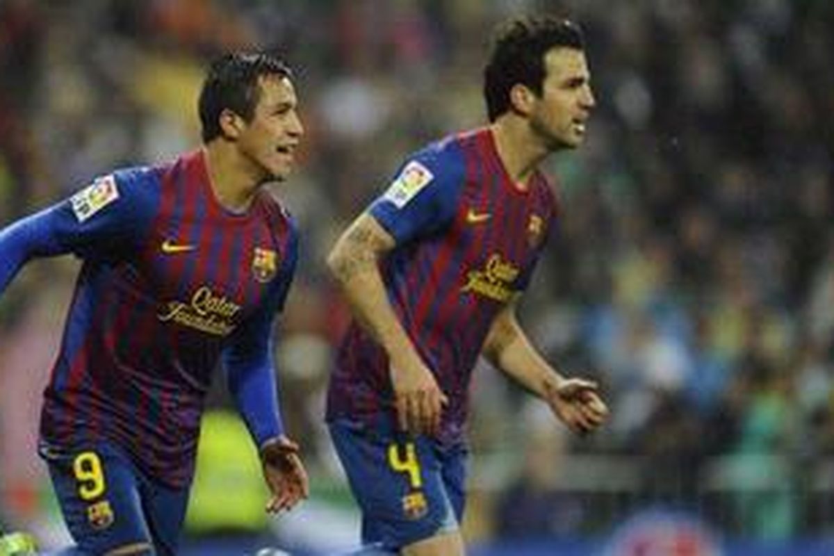 Pemain Barcelona Alexis Sanchez (kiri) merayakan gol bersama gelandang Cesc Fabregas pada pertandingan Liga Divisi Primera Spanyol melawan Real Madrid di Santiago Bernabeu, Madrid, Sabtu (10/12/2011).