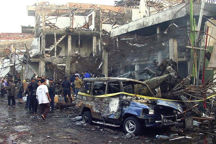 Foto pada 13 Oktober 2002 memperlihatkan para polisi memeriksa reruntuhan kelab malam yang hancur akibat bom Bali di Denpasar. Otak serangan Bom Bali 2002, Hambali, disidang di Guantanamo, Amerika Serikat, pada Senin (30/8/2021).