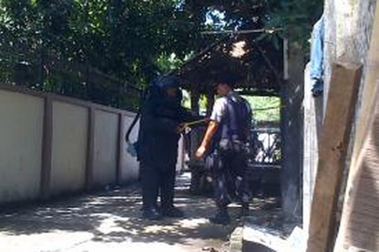 Polisi mengamankan barang yang diduga bom asap di salah satu halaman rumah milik warga Bambu Runcing, saat proses eksekusi berlangsung.
