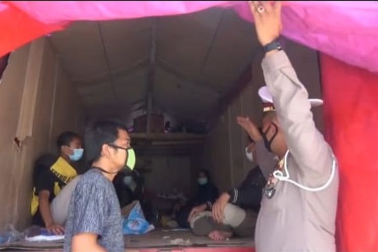 Pemudik dari Jakarta ke Ponorogo ini nekat membawa keluarganya di belakang truk . Untuk mengelabuhi petugas mereka memasang terpal pada bagian belakang truk.