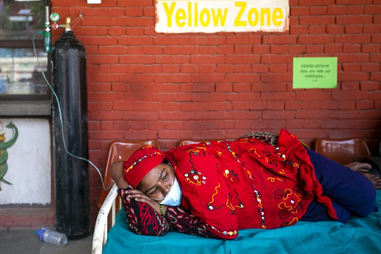Seorang wanita Nepal menerima oksigen setelah mengalami kesulitan bernapas saat menunggu hasil tes Covid-19 di luar bangsal darurat sebuah rumah sakit di Kathmandu, Nepal, Jumat (30/4/2021).