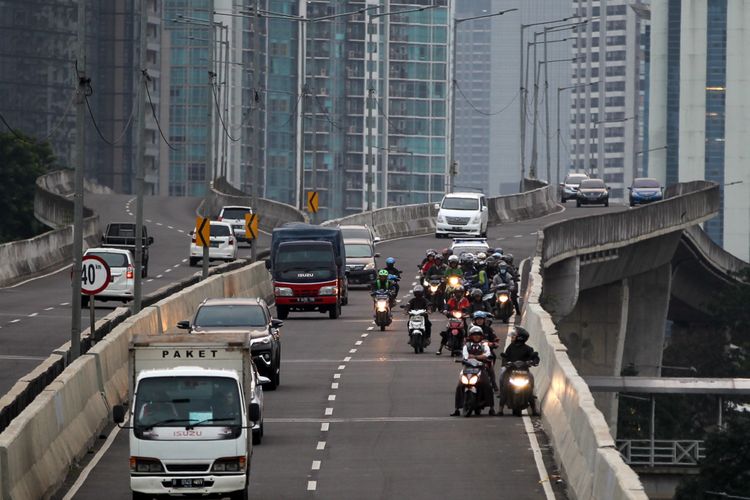 Polisi melakukan razia sepeda motor yang nekat menerobos ke jalan layang non tol (JLNT) Kampung Melayu-Tanah Abang, Jakarta, Selasa (25/7/2017). Pengendara motor masih nekat memasuki dan melintasi JLNT tersebut baik dari arah Tanah Abang maupun Kampung Melayu. KOMPAS IMAGES/KRISTIANTO PURNOMO