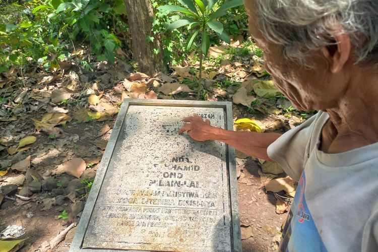 Salah satu warga Plumbon, Ahmad Khamin menunjukkan nama-nama yang dikubur di makam hutan Plumbon, Jumat (30/9/2022).