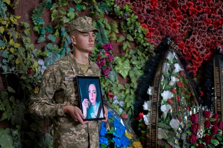 Seorang tentara Ukraina memegang foto Olga Simonova, perempuan Rusia yang tewas membela Ukraina dalam pertempuran melawan Rusia di wilayah Donetsk, Kyiv, Ukraina, Sabtu, 16 September 2022.