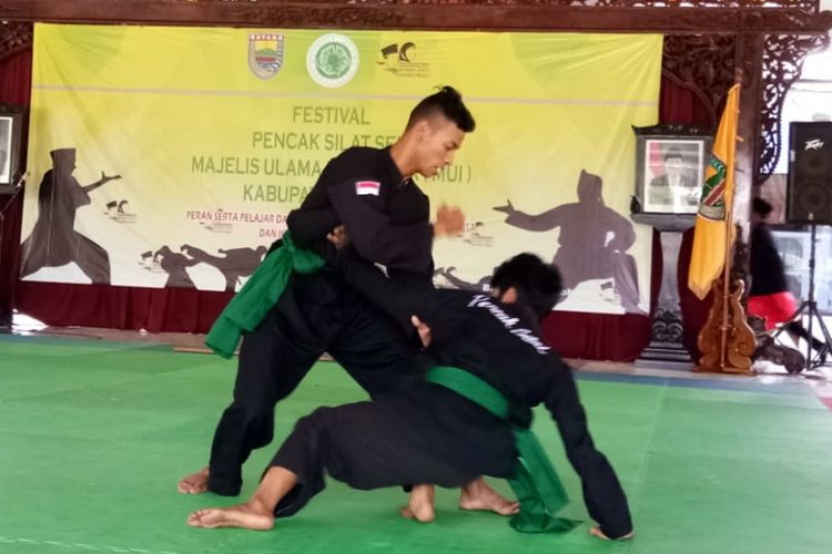 Dua atlet pencak silat sedang bertanding di Pendopo Kabupaten Batang, Jawa Tengah dalam ajang Festival Pencak Silat 2018.