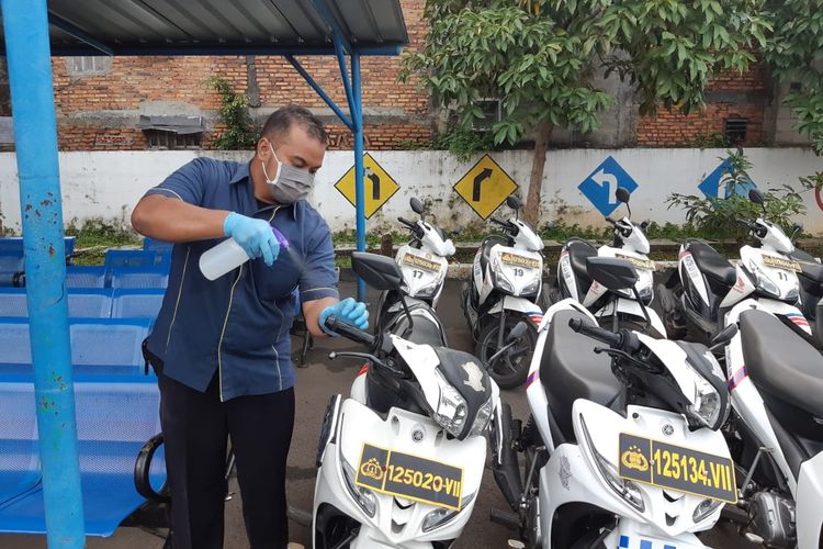 Petugas SATPAS SIM menyemprotkan Disinfektan ke salah satu kendaraan uji praktik SIM 