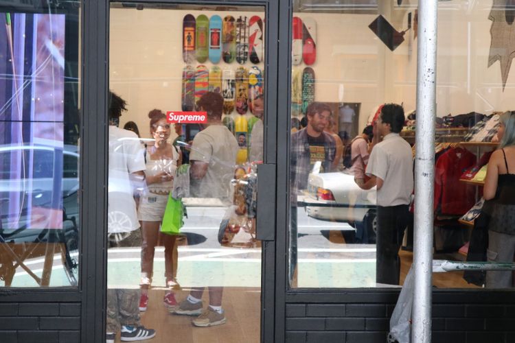 Suasana di dalam toko skateboard Supreme di Lafayette St, New York, Rabu (23/8/2017) dilihat dari luar saat antrean mengular.