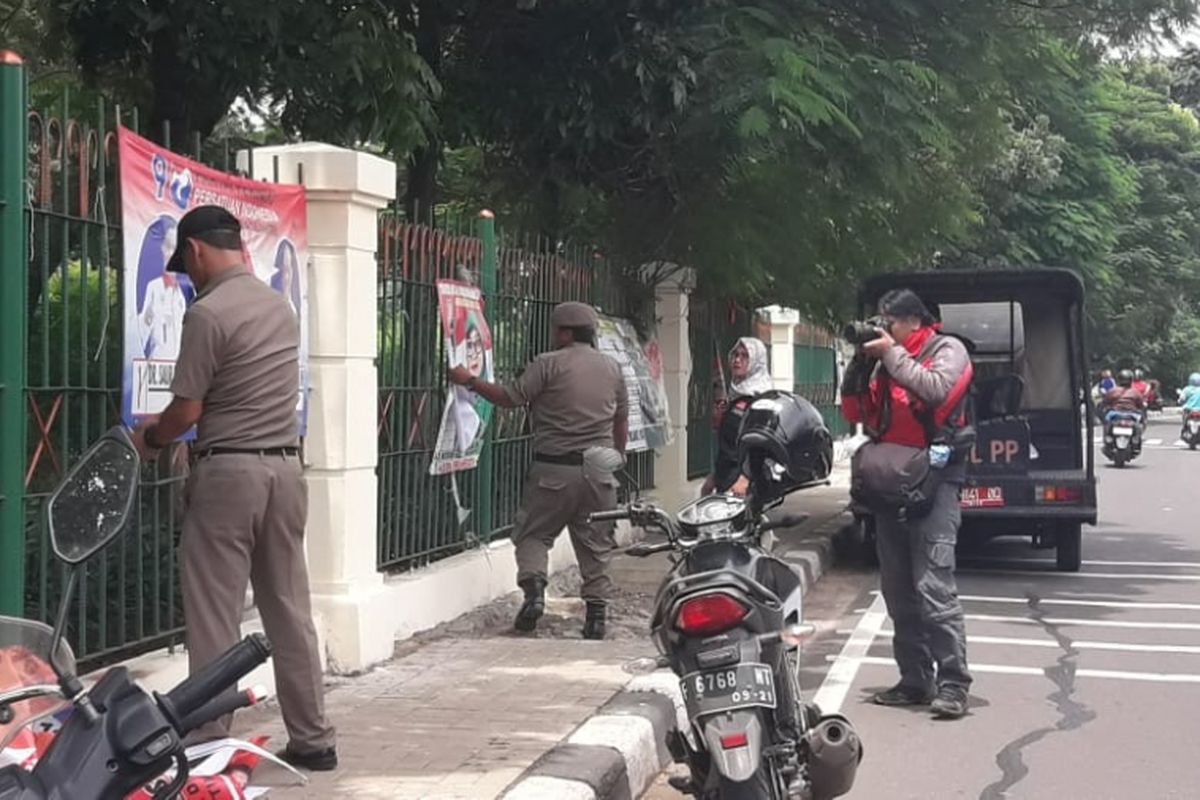 Satpol PP Jakarta Timur copot spanduk kampanye caleg yang dipasang di tempat yang dilarang di Ciracas, Jakarta Timur, Rabu (23/1/2019)