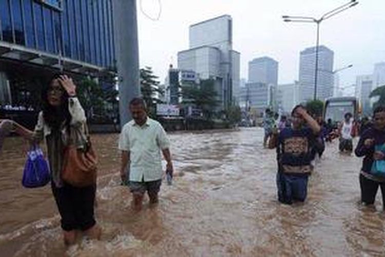 Para karyawan menmebus banjir yang menggenangi Jalan MH Thamrin, Jakarta, Kamis (17/1/2013). Akibatnyta lalu luntas di kawasan jantung ibu kota tersebut lumpuh total. Para karyawan menembus banjir.
