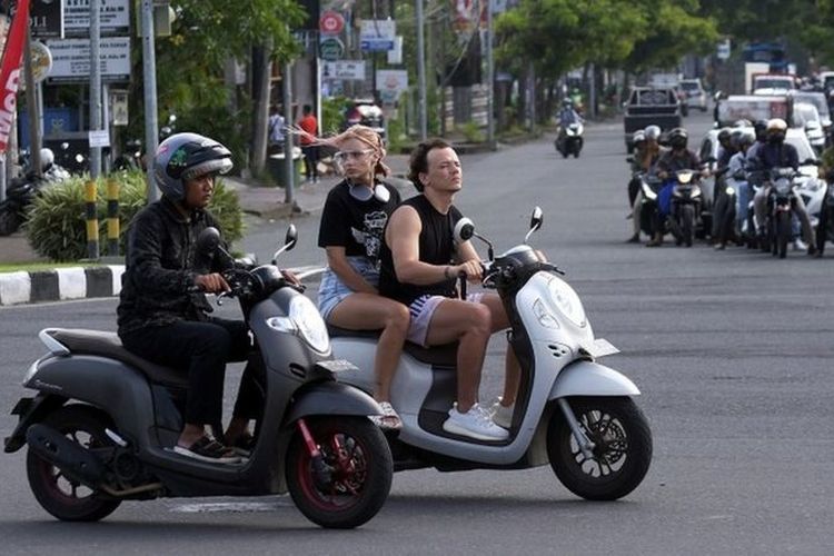 Sejumlah turis asing mengendarai sepeda motor tanpa mengenakan helm di Jalan Sunset Road, Kuta, Badung, Bali, Selasa (28/2/2023).