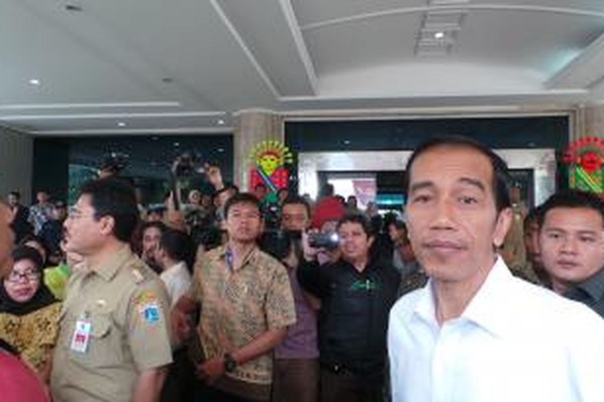 Gubernur DKI Jakarta Joko Widodo (kanan) memberikan santunan kepada warga dan memantau pasar murah yang diselenggarakan di kantor Wali Kota Jakarta Utara, Rabu (24/7/2013).