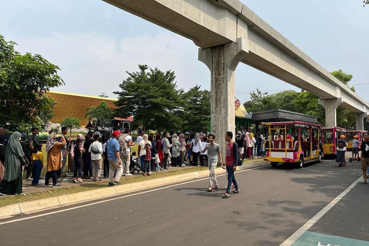 Antrian panjang pengguna mobil wara wiri di Taman Mini Indonesia Indah saat libur Nataru, Senin (25/12/2023). 