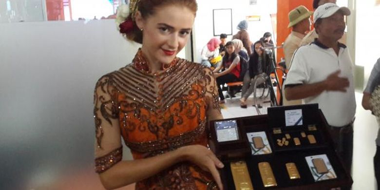 Seorang model saat menampilkan model emas batangan dalam grand launching kerja sama antara PT Pos Indonesia dan PT Antam di Kantor Pos Malang, Senin (6/2/2017)