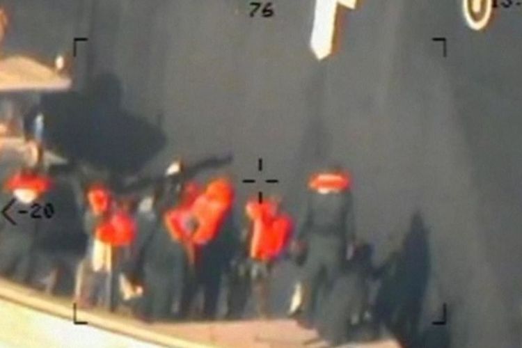 Gambar yang dirilis Angkatan Laut Amerika Serikat memperlihatkan sosok seperti pasukan Garda Revolusi Iran mencabut ranjau di kapal tanker ketika terjadi serangan di Teluk Oman Kamis pekan lalu (13/6/2019).